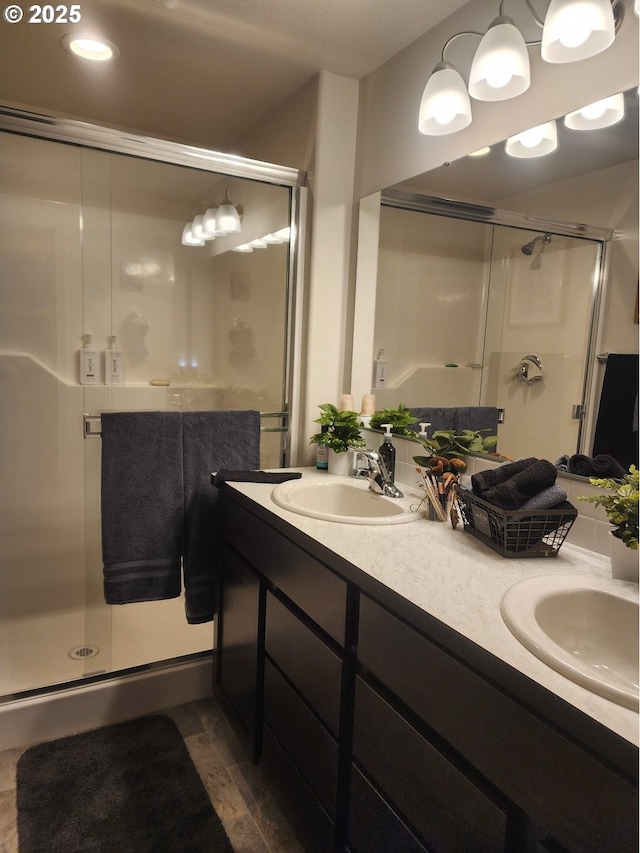 full bathroom featuring a sink, a shower stall, and double vanity