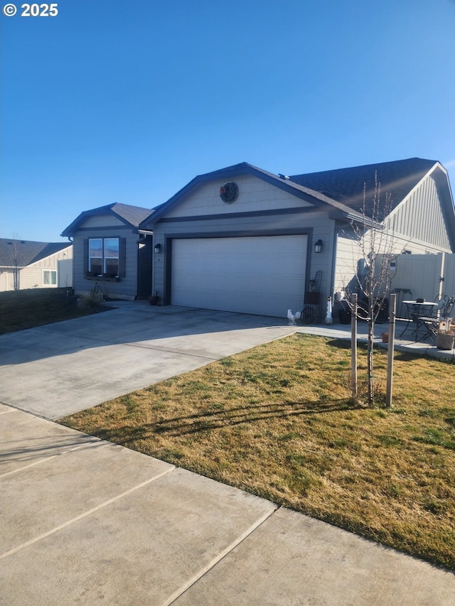 ranch-style home featuring a garage, driveway, and a front lawn