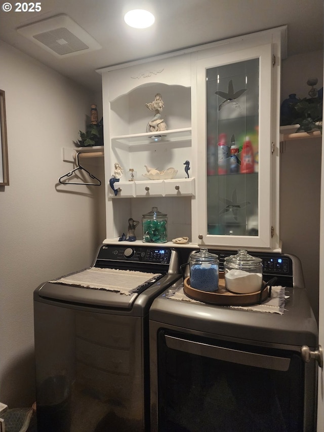 washroom featuring laundry area, separate washer and dryer, and visible vents