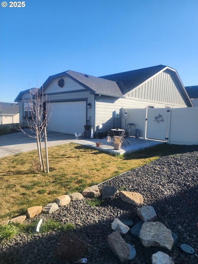 ranch-style home featuring an attached garage, a gate, fence, driveway, and a front lawn