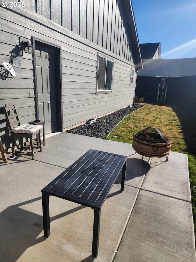 view of patio featuring fence and a fire pit