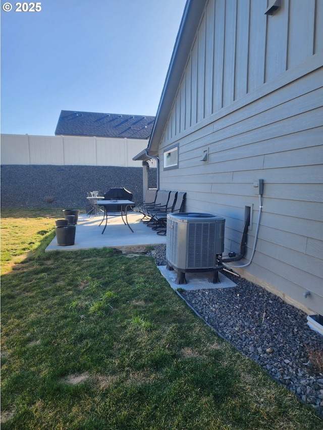 view of yard with a patio, fence, and central air condition unit