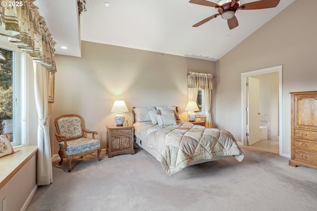 bedroom with ceiling fan, multiple windows, connected bathroom, and light colored carpet