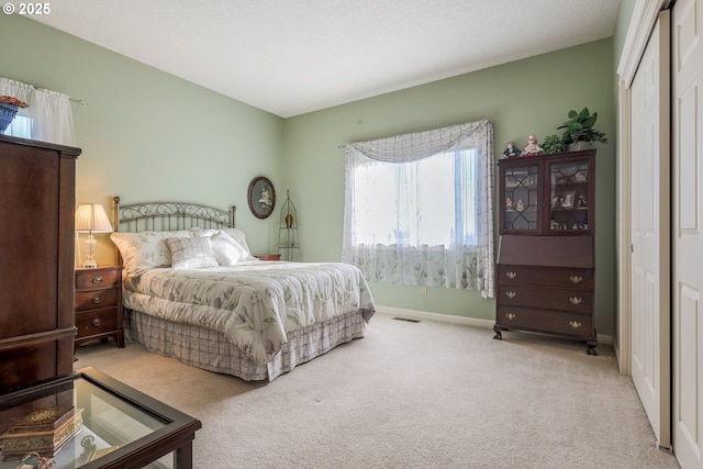 bedroom with light colored carpet and a closet