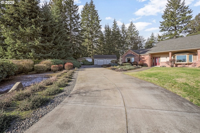 view of front of home with a garage, a front yard, and an outbuilding