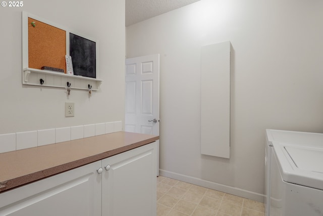 laundry area featuring cabinets, a textured ceiling, and washing machine and dryer