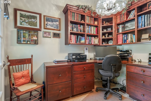 office area with a notable chandelier and light carpet