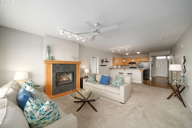 1108 S Holladay Dr Unit 24, Seaside, OR 97138 - living room with carpet flooring, a tiled fireplace, track lighting, and a ceiling fan