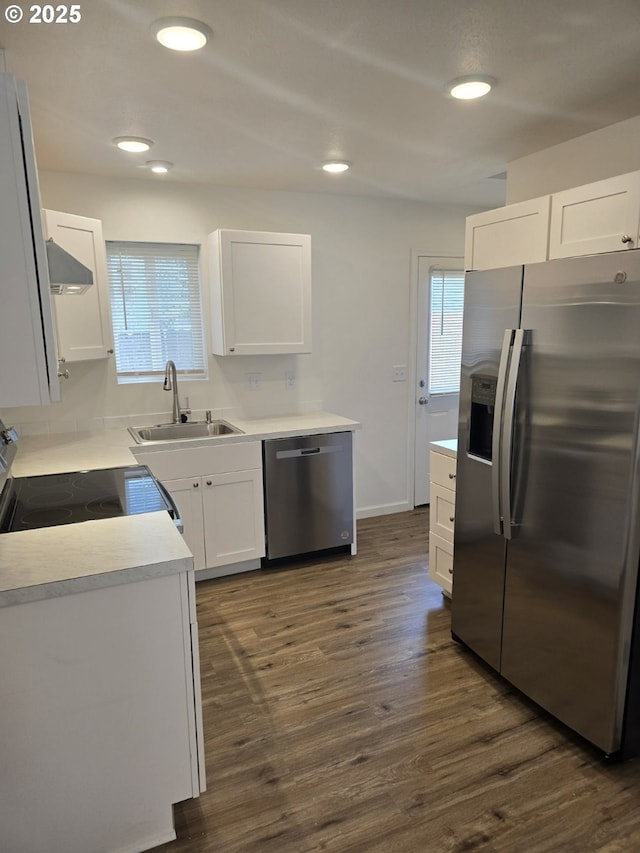 3461 Concord St, Eugene, OR 97402 - kitchen with appliances with stainless steel finishes, dark wood finished floors, white cabinets, wall chimney range hood, and recessed lighting