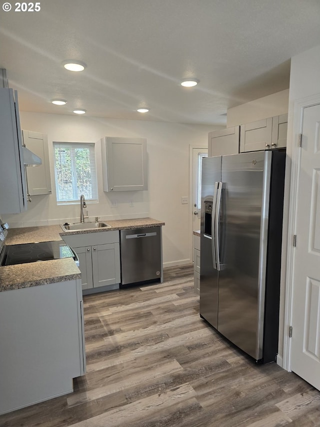 3461 Concord St, Eugene, OR 97402 - kitchen featuring appliances with stainless steel finishes, wood finished floors, recessed lighting, range hood, and gray cabinets
