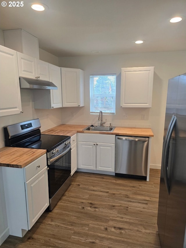 3461 Concord St, Eugene, OR 97402 - kitchen with wood counters, stainless steel appliances, under cabinet range hood, white cabinetry, and dark wood-type flooring
