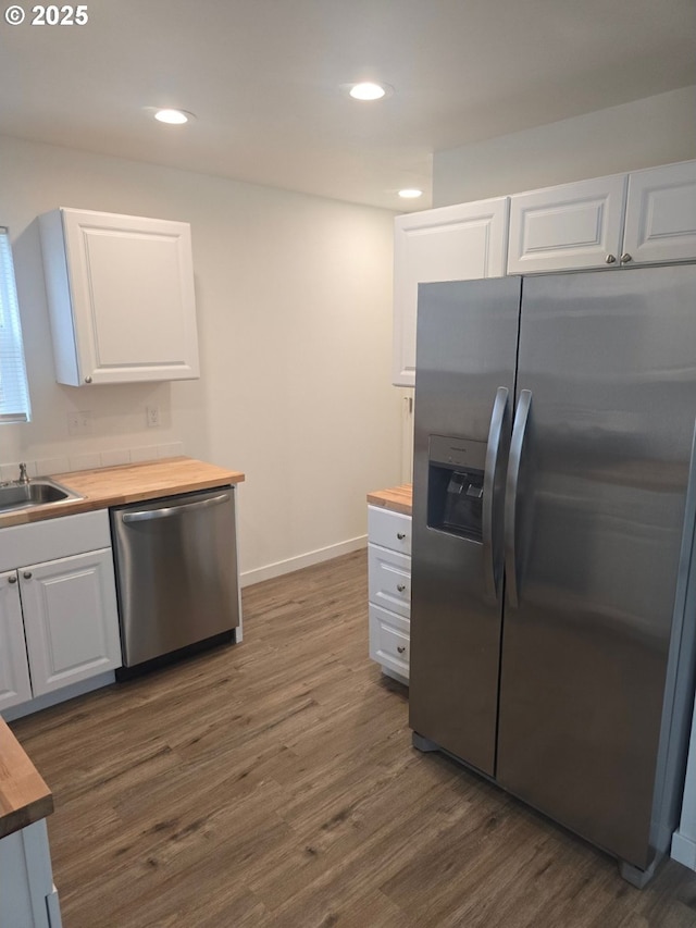 3461 Concord St, Eugene, OR 97402 - kitchen featuring appliances with stainless steel finishes, wooden counters, dark wood-style floors, white cabinetry, and recessed lighting