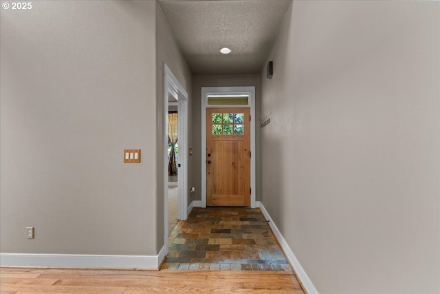 7444 SE 114th Ave, Portland, OR 97266 - entryway featuring baseboards, stone finish flooring, and a textured ceiling