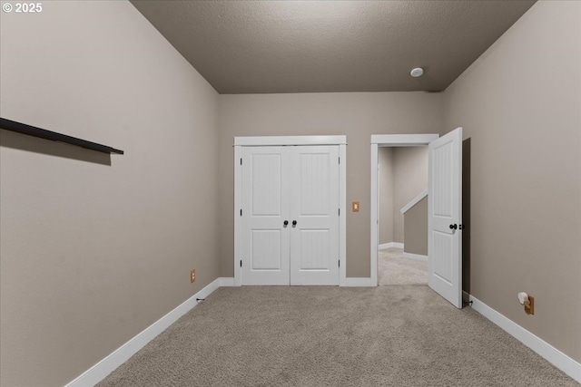 7444 SE 114th Ave, Portland, OR 97266 - unfurnished bedroom with light colored carpet, baseboards, a textured ceiling, and a closet