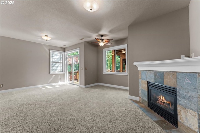 7444 SE 114th Ave, Portland, OR 97266 - unfurnished living room featuring a tile fireplace, a textured ceiling, healthy amount of natural light, baseboards, and ceiling fan