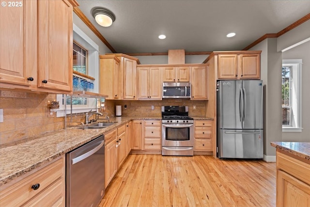 7444 SE 114th Ave, Portland, OR 97266 - kitchen featuring appliances with stainless steel finishes, light brown cabinetry, ornamental molding, light stone countertops, and light wood-style floors