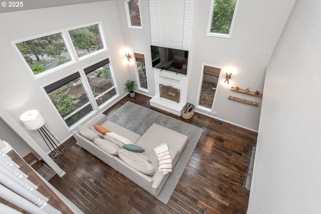 11255 SW Chickadee Ter, Beaverton, OR 97007 - living room with a high ceiling, a stone fireplace, hardwood / wood-style floors, and baseboards