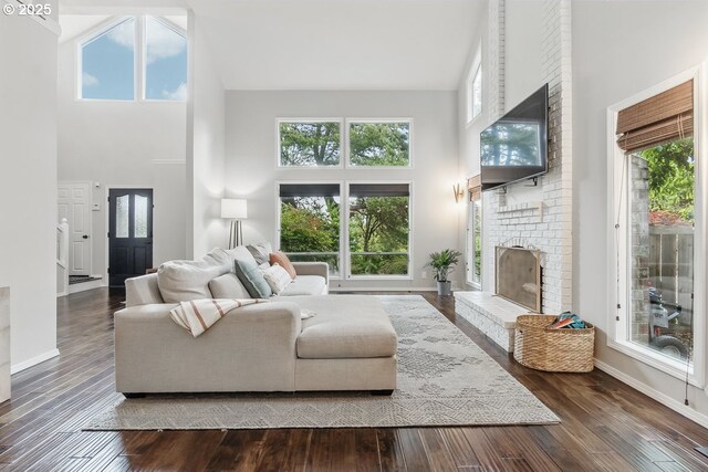 11255 SW Chickadee Ter, Beaverton, OR 97007 - living room with a high ceiling, a fireplace, hardwood / wood-style floors, plenty of natural light, and baseboards