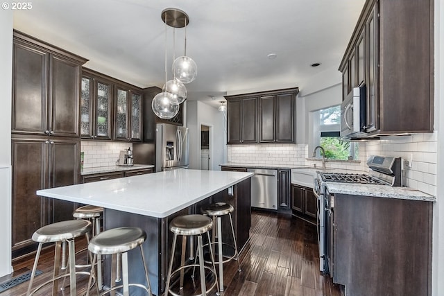 11255 SW Chickadee Ter, Beaverton, OR 97007 - kitchen featuring stainless steel appliances, a sink, dark brown cabinets, and backsplash