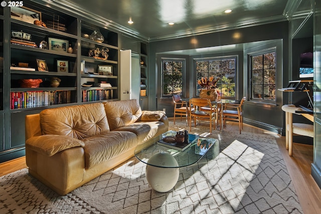 living area featuring crown molding, built in shelves, and hardwood / wood-style floors