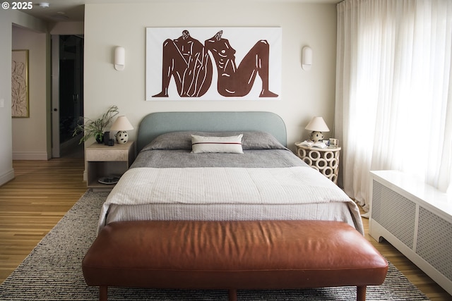 bedroom featuring radiator and hardwood / wood-style floors