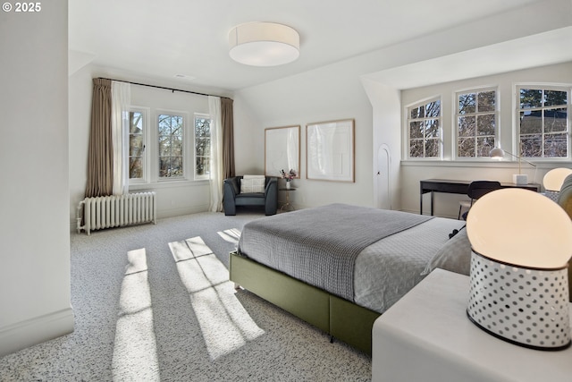 carpeted bedroom with radiator and lofted ceiling