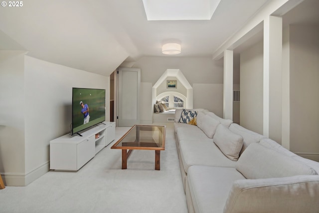 carpeted living room with vaulted ceiling with skylight