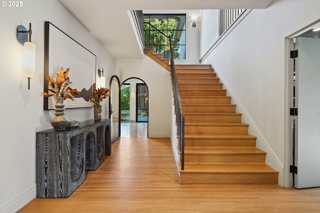 staircase featuring hardwood / wood-style flooring and a high ceiling