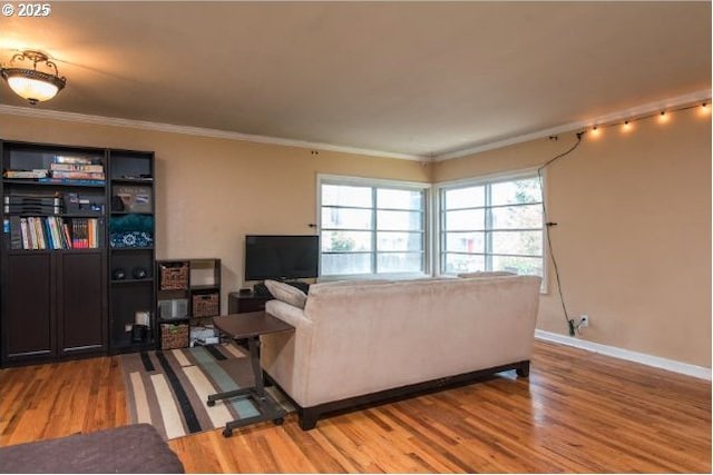 living room featuring baseboards, crown molding, and light wood-style floors