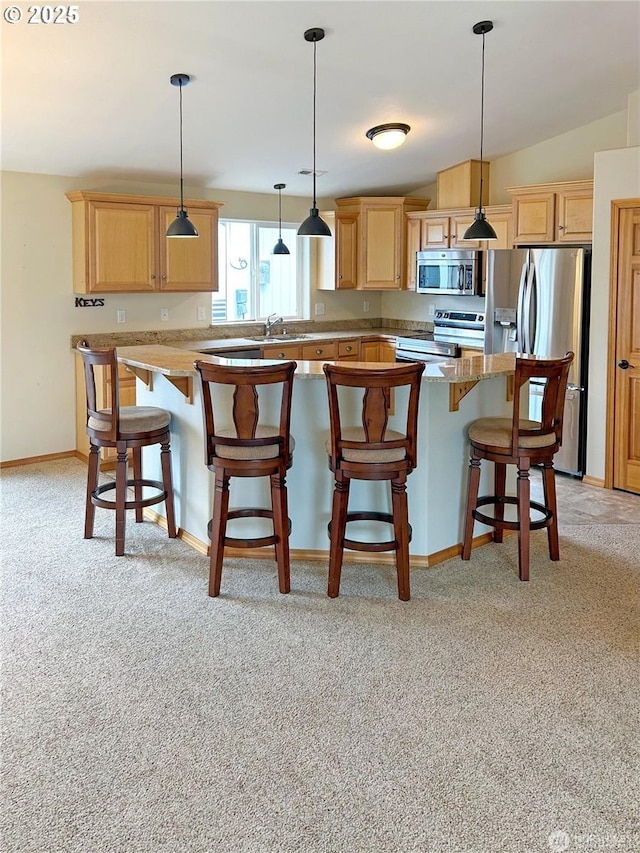 510 Oregon Ave N, Long Beach, WA 98631 - kitchen featuring appliances with stainless steel finishes, light carpet, a kitchen breakfast bar, and light brown cabinets