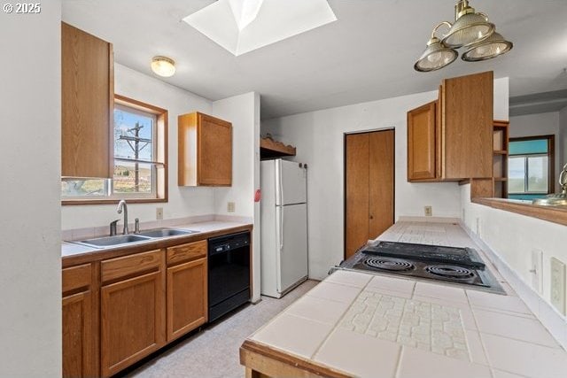 387 E Linden Way, Heppner, OR 97836 - kitchen with freestanding refrigerator, dishwasher, tile counters, and brown cabinetry