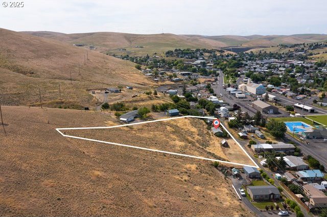 387 E Linden Way, Heppner, OR 97836 - aerial overview of property's location with a mountain backdrop and property parcel outlined