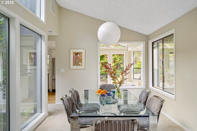 dining space with vaulted ceiling, carpet floors, a textured ceiling, baseboards, and visible vents