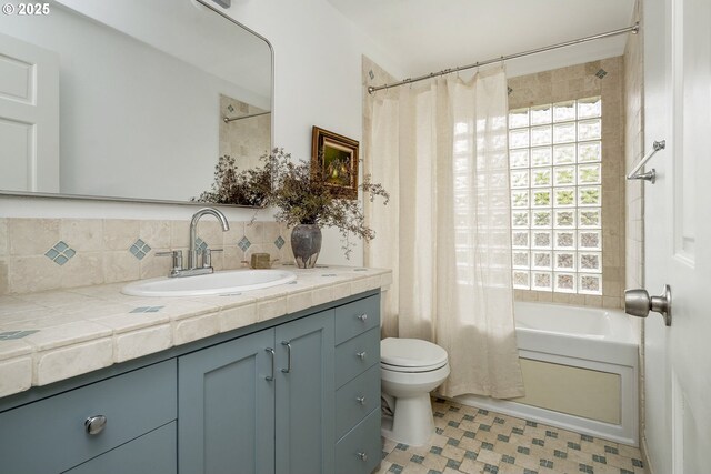 full bathroom with vanity, toilet, backsplash, tile patterned floors, and shower / bath combo