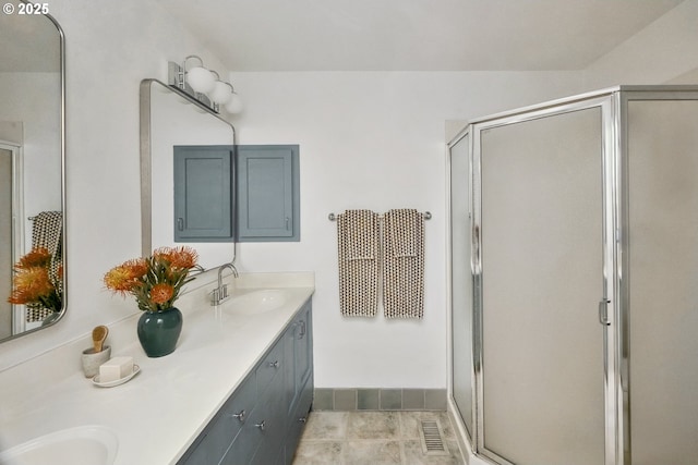 full bathroom with a stall shower, double vanity, visible vents, and a sink