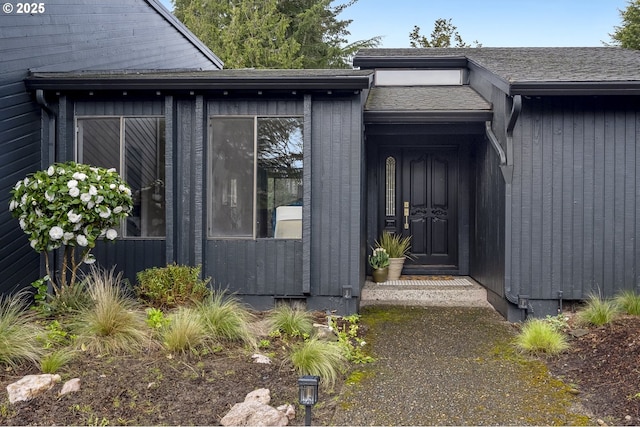entrance to property featuring a shingled roof