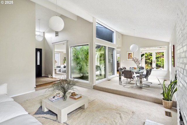 carpeted living room featuring high vaulted ceiling, french doors, a textured ceiling, baseboards, and visible vents