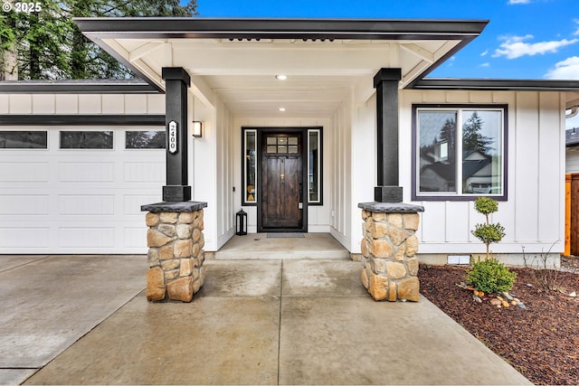 doorway to property featuring crawl space, driveway, a garage, and board and batten siding