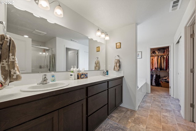 3 Patty Cir, Milton-Freewater, OR 97862 - bathroom featuring a stall shower, double vanity, a walk in closet, stone finish floors, and baseboards