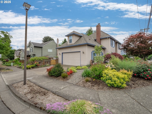 view of front facade with driveway, an attached garage, roof with shingles, and fence