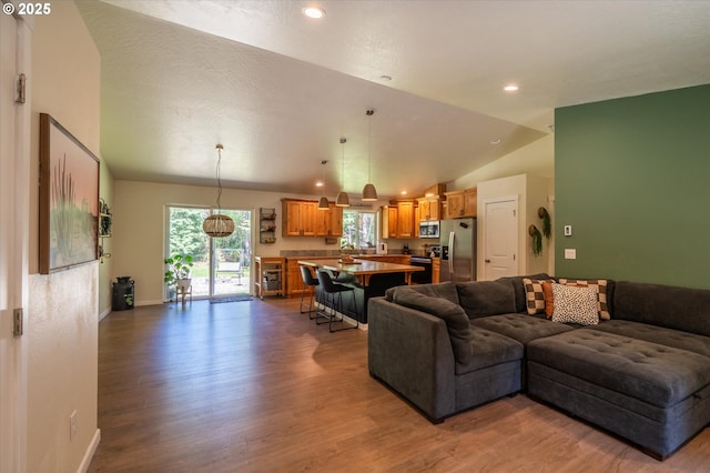 56502 Tom Smith Rd, Bandon, OR 97411 - living area featuring wood finished floors, vaulted ceiling, recessed lighting, and baseboards