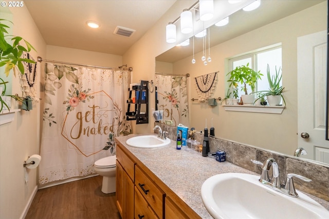 56502 Tom Smith Rd, Bandon, OR 97411 - full bathroom featuring wood finished floors, toilet, and double vanity