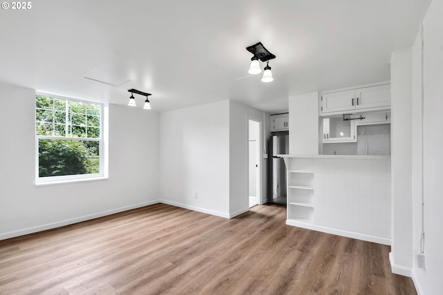 20 NW 16th Ave Unit 4, Portland, OR 97209 - unfurnished living room with baseboards and wood finished floors