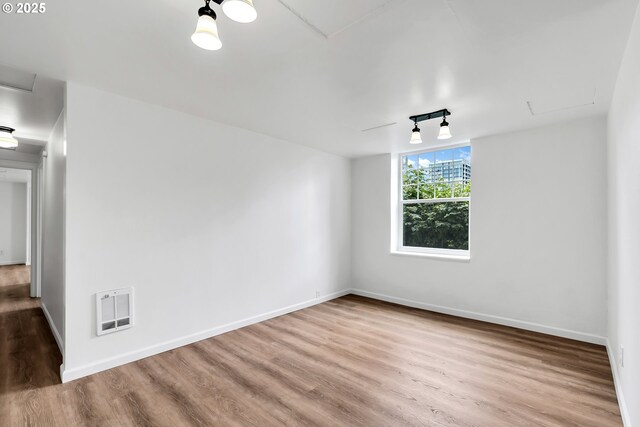 20 NW 16th Ave Unit 4, Portland, OR 97209 - empty room with attic access, wood finished floors, baseboards, and heating unit