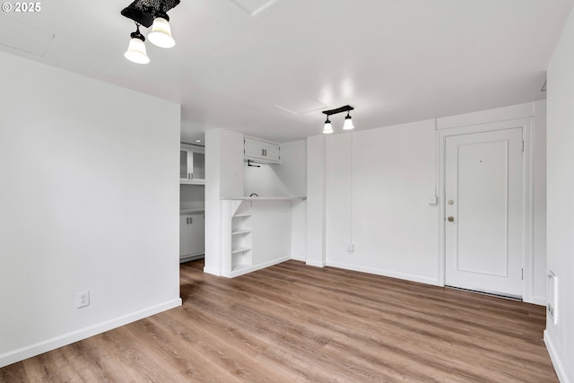 20 NW 16th Ave Unit 4, Portland, OR 97209 - unfurnished living room with attic access, light wood-style floors, baseboards, and built in features