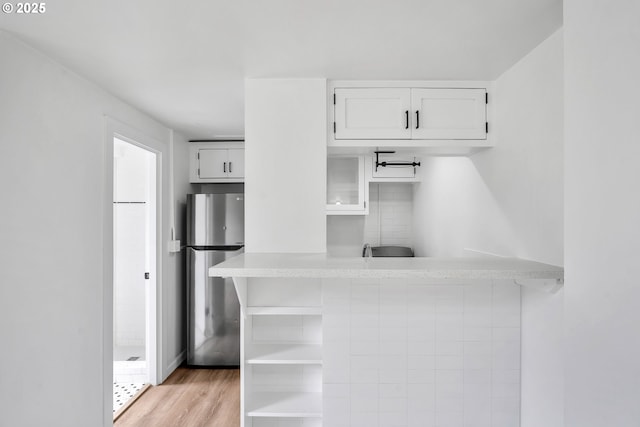 20 NW 16th Ave Unit 4, Portland, OR 97209 - kitchen featuring freestanding refrigerator, white cabinetry, light countertops, light wood-style floors, and open shelves