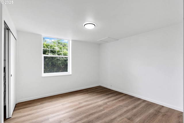 20 NW 16th Ave Unit 4, Portland, OR 97209 - unfurnished bedroom with wood finished floors, baseboards, a closet, and attic access