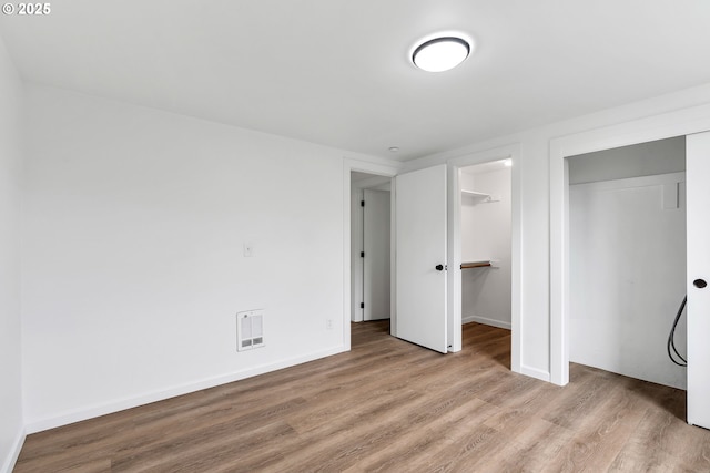 20 NW 16th Ave Unit 4, Portland, OR 97209 - unfurnished bedroom with wood finished floors, baseboards, and heating unit