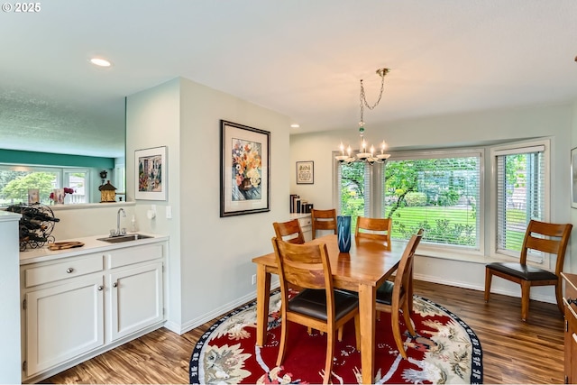 7605 SW Arbor Glen Ct, Wilsonville, OR 97070 - dining room featuring light wood-style flooring, a chandelier, recessed lighting, and bar with sink