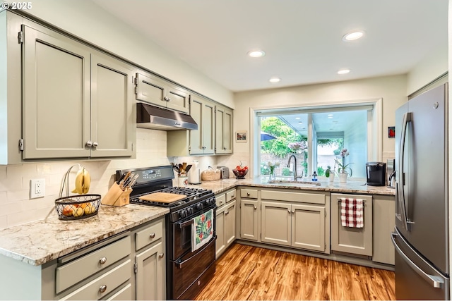 7605 SW Arbor Glen Ct, Wilsonville, OR 97070 - kitchen with range with two ovens, freestanding refrigerator, under cabinet range hood, light wood-type flooring, and decorative backsplash